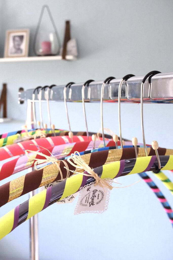 Bunte Hula-Hoop-Reifen hängen nebeneinander an einer Stange.
